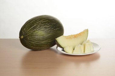 Kavunu aç ve masanın üzerindeki tabakta küçük bir dilim