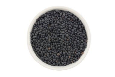 Beyaz arka planda beyaz bir seramik kasede siyah mercimek.