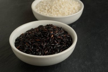 Farklı renkte iki beyaz kase, siyah ve beyaz yuvarlak taş arka plan, üst manzara.