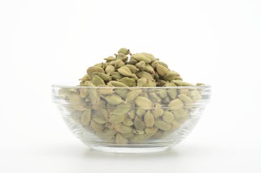 Beyaz arka planda şeffaf cam bir kasede kakule.