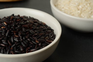 Farklı renkte iki beyaz kase, siyah ve beyaz yuvarlak taş arka plan, üst manzara.