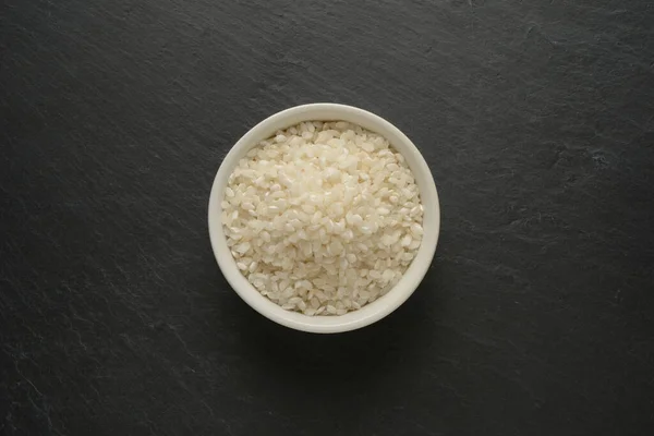 Στρογγυλό Άσπρο Ρύζι Λευκό Κεραμικό Μπολ Μαύρο Πέτρινο Φόντο Πάνω — Φωτογραφία Αρχείου