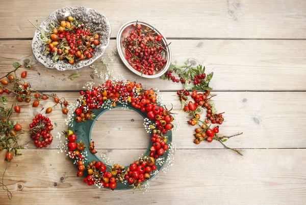 Steps of making door wreath with rose hip, hawthorn and rowan berry. Party decor