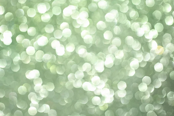 Green glittering christmas lights. Blurred abstract background.