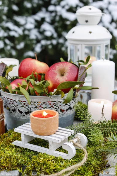 Christmas garden decoration with apples and lanterns. Festive decor