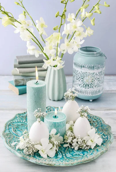 Easter floral decoration with goose egg, orchid flowers and gypsophila paniculata twigs.