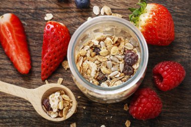 Kavanoz müsli ve çevresinde taze çilek. Kahvaltı saati