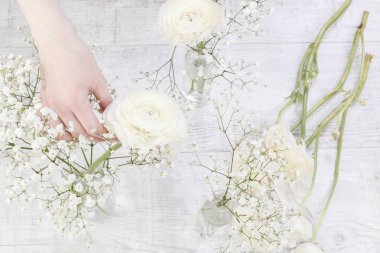 Çiçekçi iş: dekorasyon Düğünçiçeği çiçek ve beyaz gypsophila paniculata yapma kadın. Adım adım, öğretici.