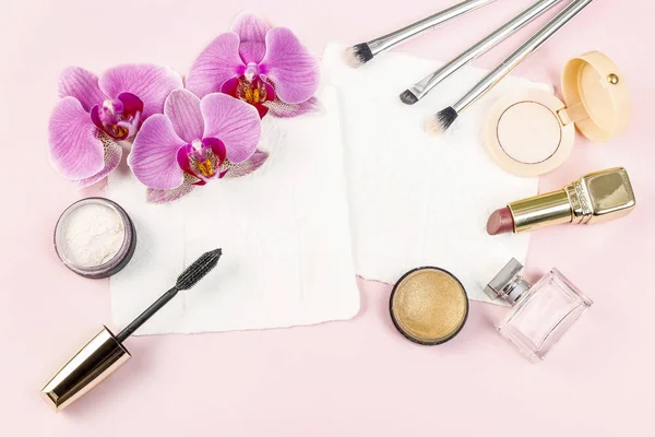 Cosmetici e fiori su sfondo rosa . — Foto Stock