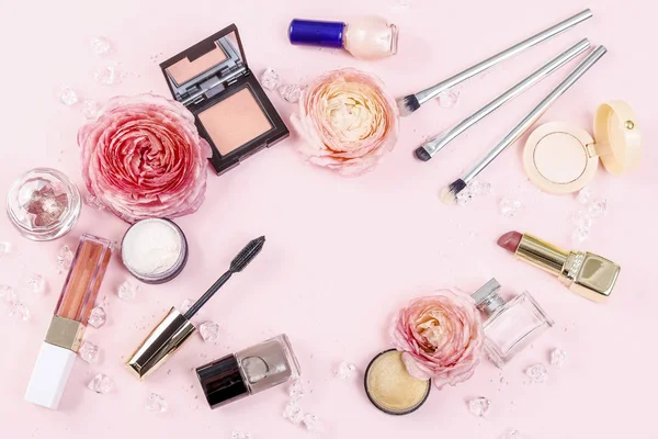 Kosmetik og blomster på lyserød baggrund . - Stock-foto
