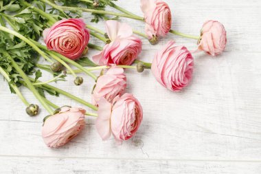 Beyaz ahşap masada pembe Ranunculus çiçekler