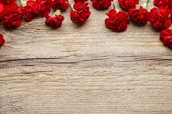 Red carnations on wood — Stock Photo, Image