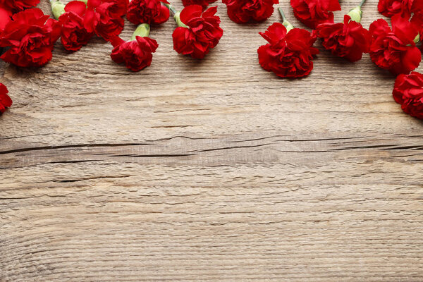 Red carnations on wood