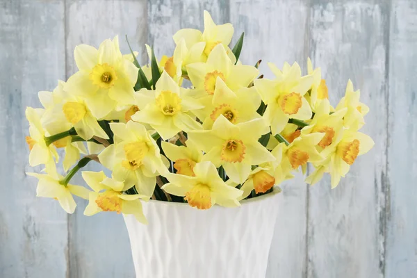 Buquê de narcisos amarelos em vaso de cerâmica branca . — Fotografia de Stock