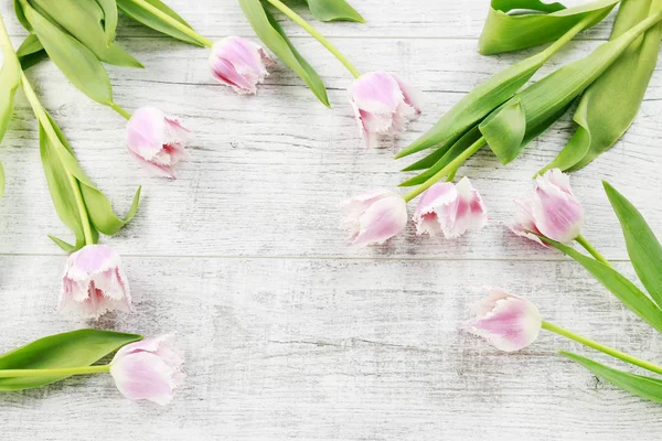 Růžové tulipány na dřevěném pozadí — Stock fotografie