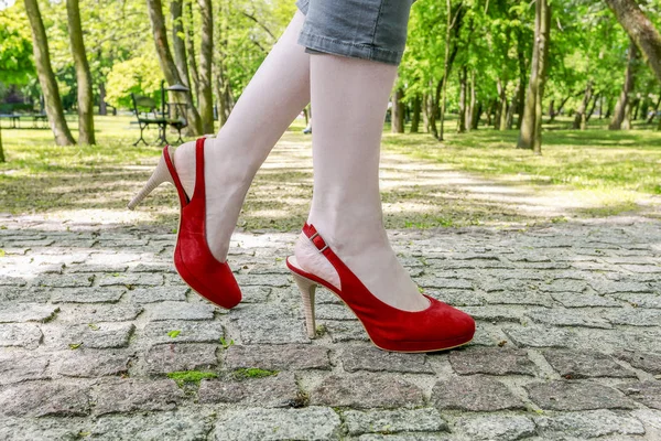 Mujer joven con zapatos de slingback, caminando sobre el pastel empedrado — Foto de Stock