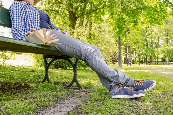 Donna che legge un libro, seduta sulla panchina in un parco — Foto Stock