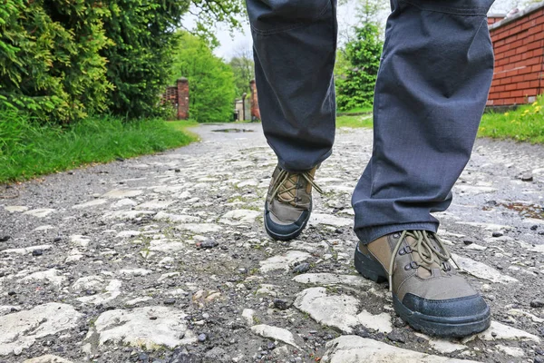 Jovem usando botas de caminhada, andando na estrada rochosa . — Fotografia de Stock