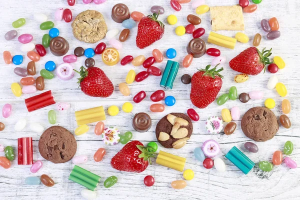 Fruit, koekjes en snoepjes op witte houten tafel. — Stockfoto