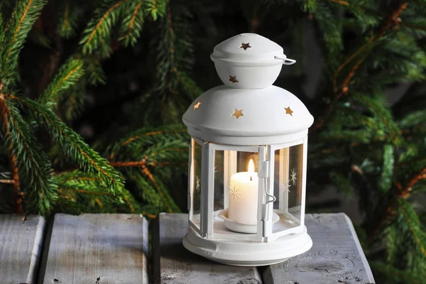 White lantern on wooden table under fir branch. — Stock Photo, Image