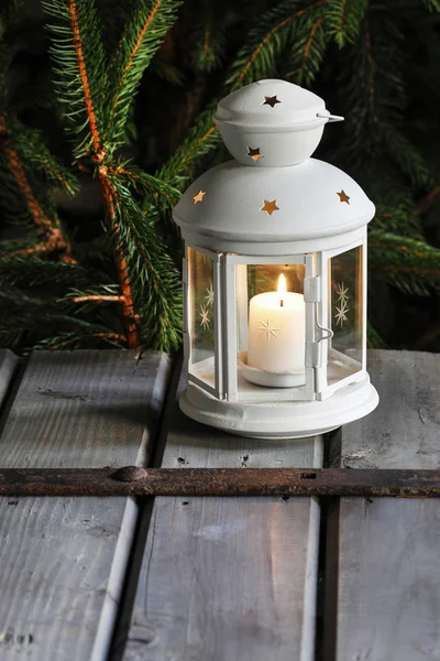 Witte lantaarn op houten tafel onder tak van de zilverspar. — Stockfoto