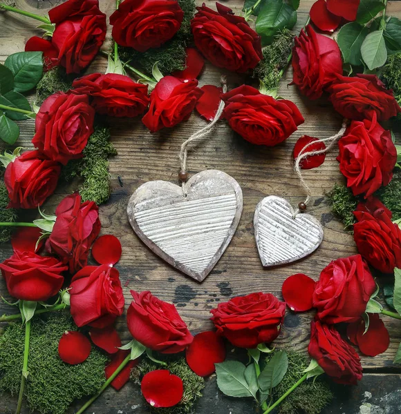 Red roses and two hearts on wood — Stock Photo, Image