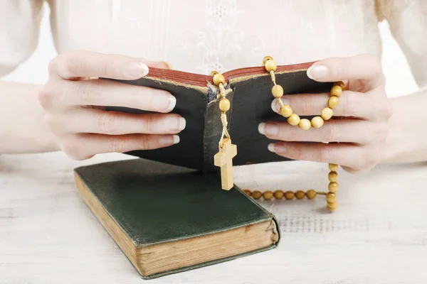 Woman holding Holy Bible and wooden rosary. — Stock Photo, Image