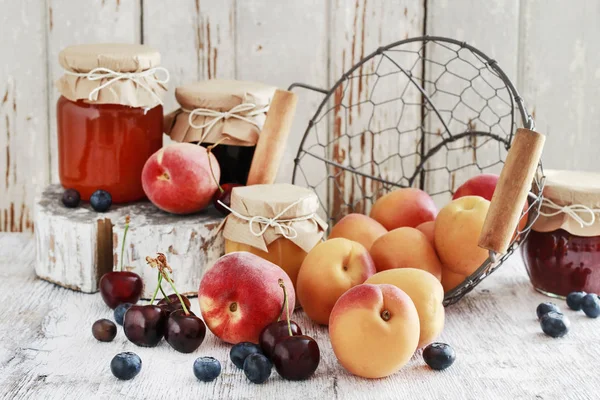 Sommarfrukter och tre burkar med sylt i trä skafferi. — Stockfoto