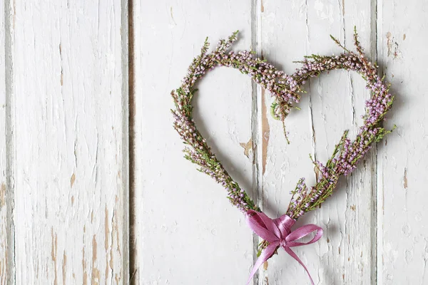 Heather (erica) kapı çelengi ahşap arka plan üzerinde kalp şeklinde — Stok fotoğraf