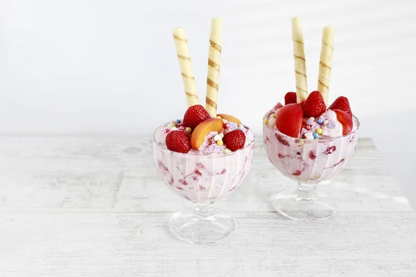 Eisdessert mit frischen Erdbeeren, Pfirsichen und knusprigem Kuchen — Stockfoto