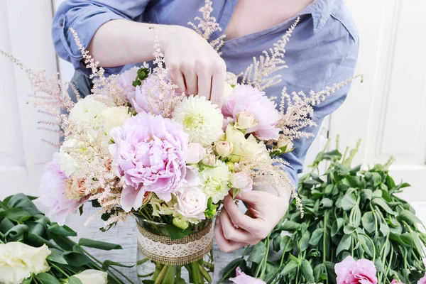 Florista no trabalho: mulher arranjando buquê com peônias rosa, rosa — Fotografia de Stock