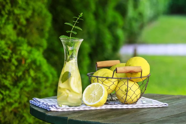 Lemonade in the bottle and fresh fruits in wire basket — Stock Photo, Image