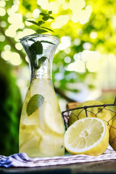 Lemonade in the bottle and fresh fruits in wire basket — Stock Photo, Image