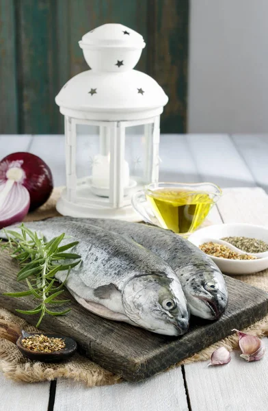 Two rainbow trouts on rustic wooden table among herbs and vegeta — Stock Photo, Image