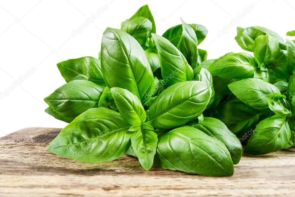 Basil leaves on wooden table.