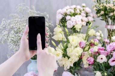Çiçekler online sipariş. Sm'si ile bitkilerin fotoğrafını çeken kadın