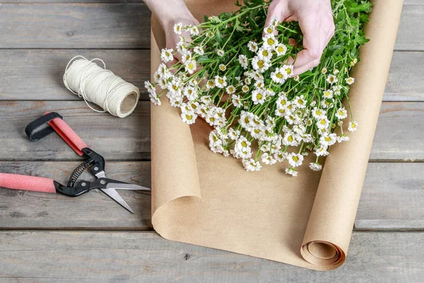 Blumenstrauß aus Matricaria tanacetum mit Papierverpackung. — Stockfoto