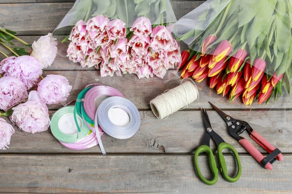 Floristik-Arbeitsplatz: Blumen und Accessoires auf Holztisch — Stockfoto