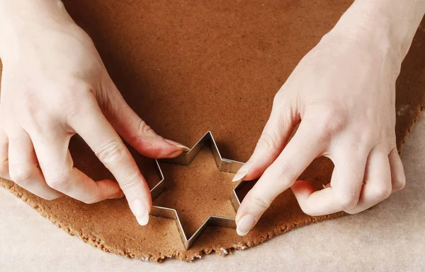 Mulher fazendo biscoitos de gengibre em forma de estrela . — Fotografia de Stock