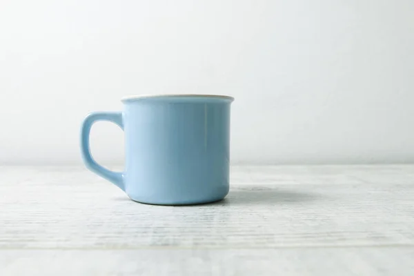 Blue mug on white wooden table
