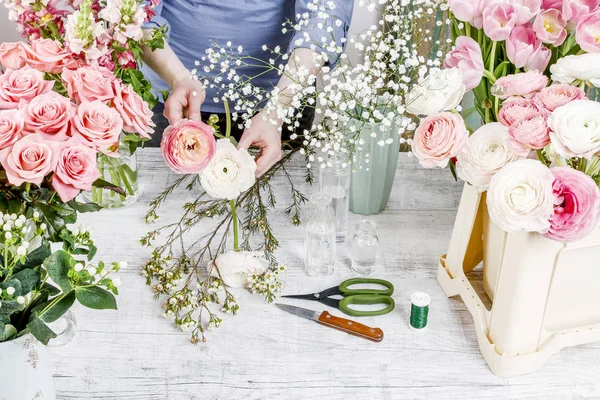 Žena aranžuje kytici s růžemi, Matthiolas, ranunculus flo — Stock fotografie