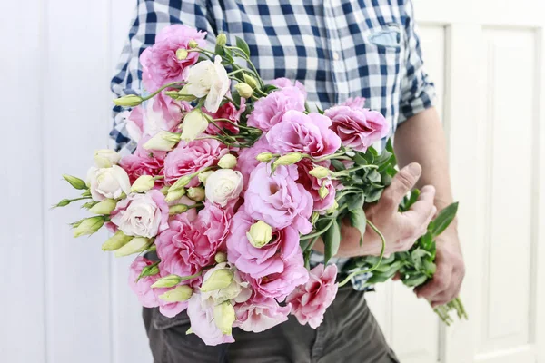 Virágárus kezében egy nagy rakás rózsaszín eustoma virágok — Stock Fotó