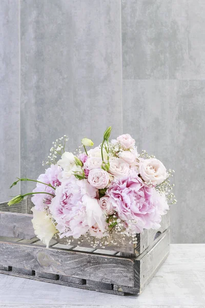 木箱にピオニとバラのピンクの花束. — ストック写真