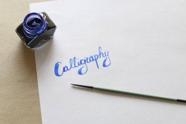 Kaligrafi, beyaz kağıda el yazısı harfler. 