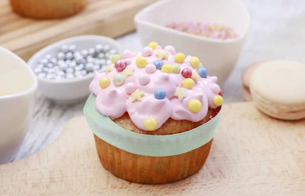 Růžové muffiny ozdobené barevným posytkami. — Stock fotografie