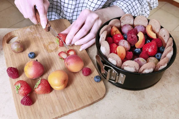 Donna che prepara torta di charlotte francese con frutta estiva a casa — Foto Stock