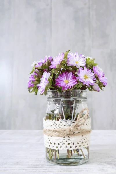 Bouquet of purple and white chrysanthemum flowers in glass jar — Stock Photo, Image