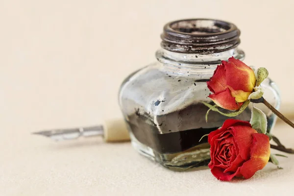 Tinta, caneta e rosas secas sobre fundo de papel vintage — Fotografia de Stock