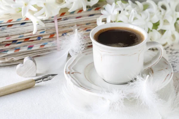Чашка кофе, стопка старых букв, гиацинтовый цветок и белый F — стоковое фото