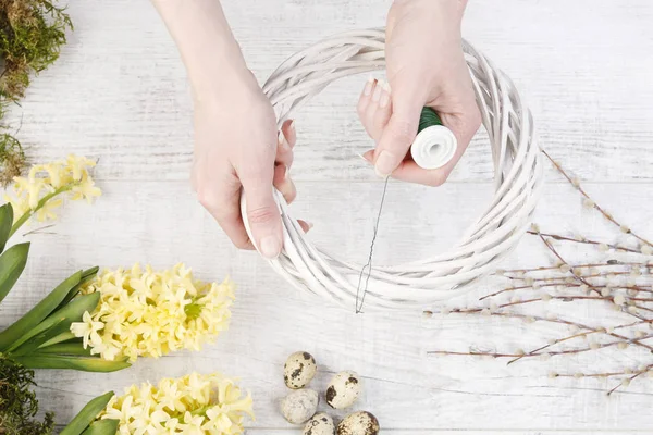 Як зробити білий плетений вінок з мохом, перепелиними яйцями і гіацином — стокове фото